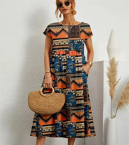 Woman wearing a patterned dress holding a straw bag against a white background