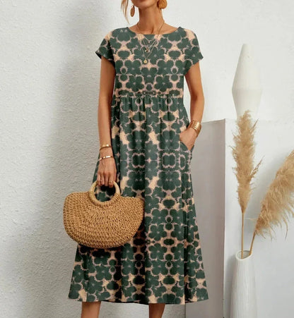 Woman wearing a green floral dress holding a woven bag against a white background