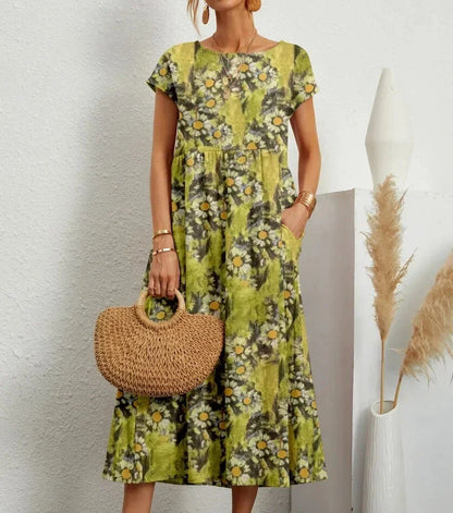 Woman wearing a floral dress holding a woven handbag against a neutral background
