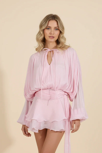 Woman wearing a pink dress against a beige background