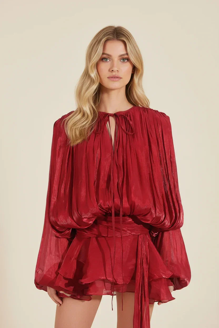 Woman wearing a red dress with long sleeves on a beige background