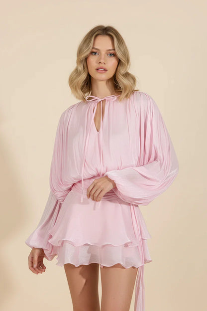 Woman wearing a pink dress against a beige background