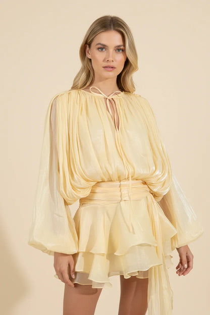 Woman wearing a yellow dress against a beige background