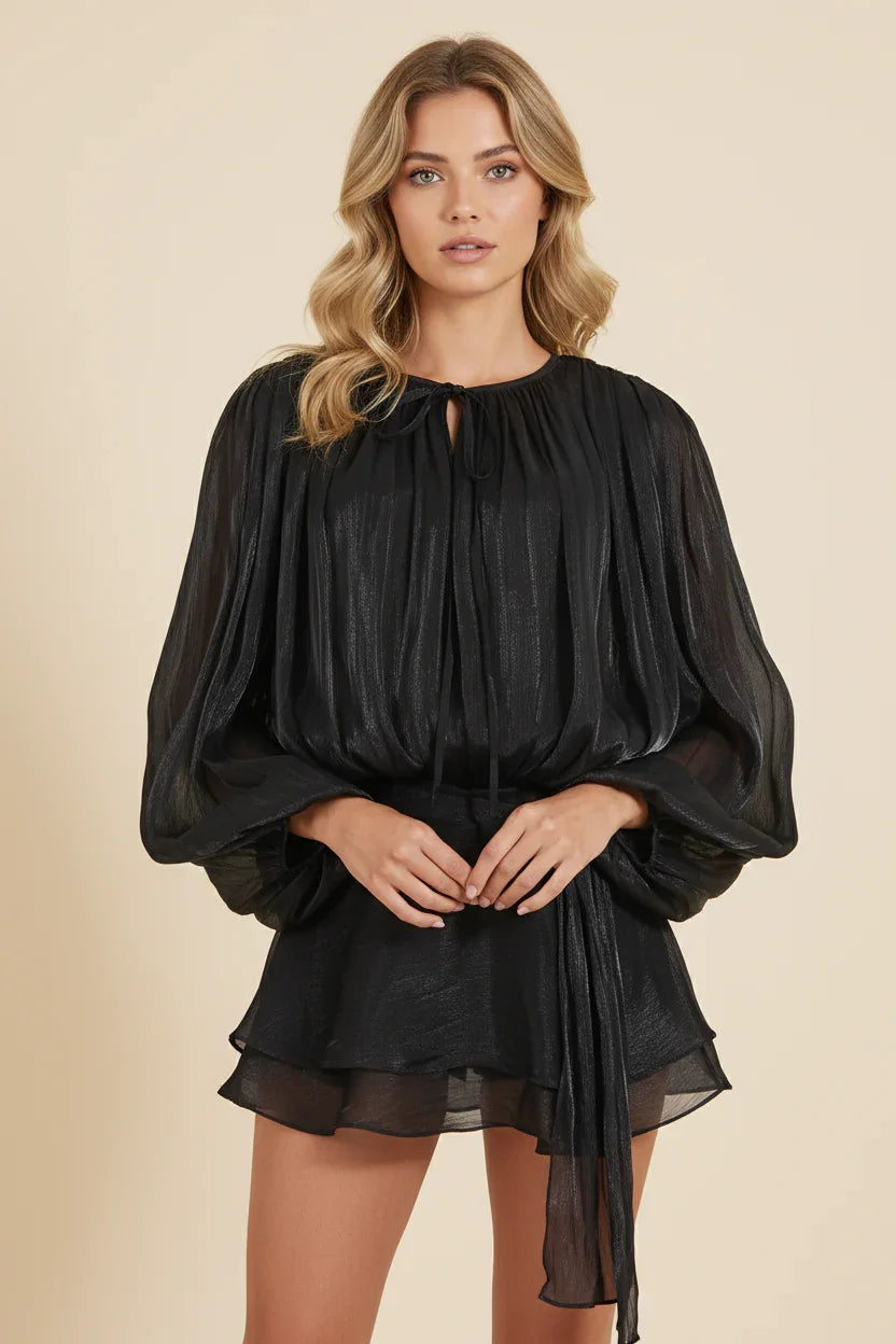Woman wearing a black dress against a beige background