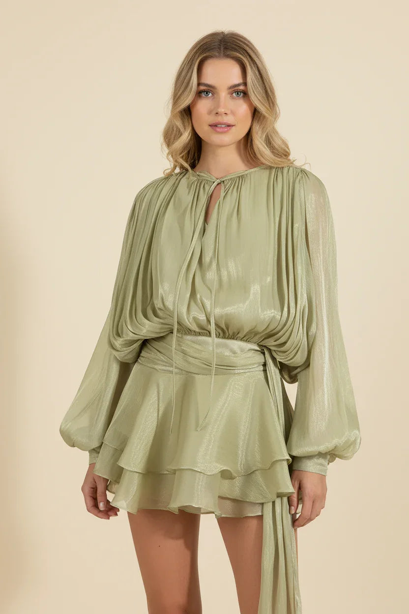 Woman wearing a green dress with long sleeves on a beige background
