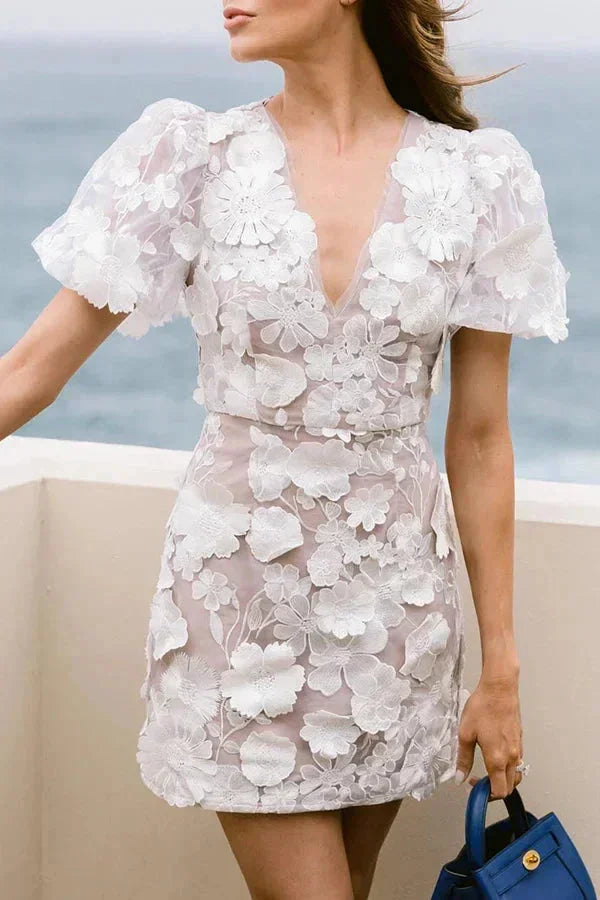 Woman wearing a white floral dress with a blurred background