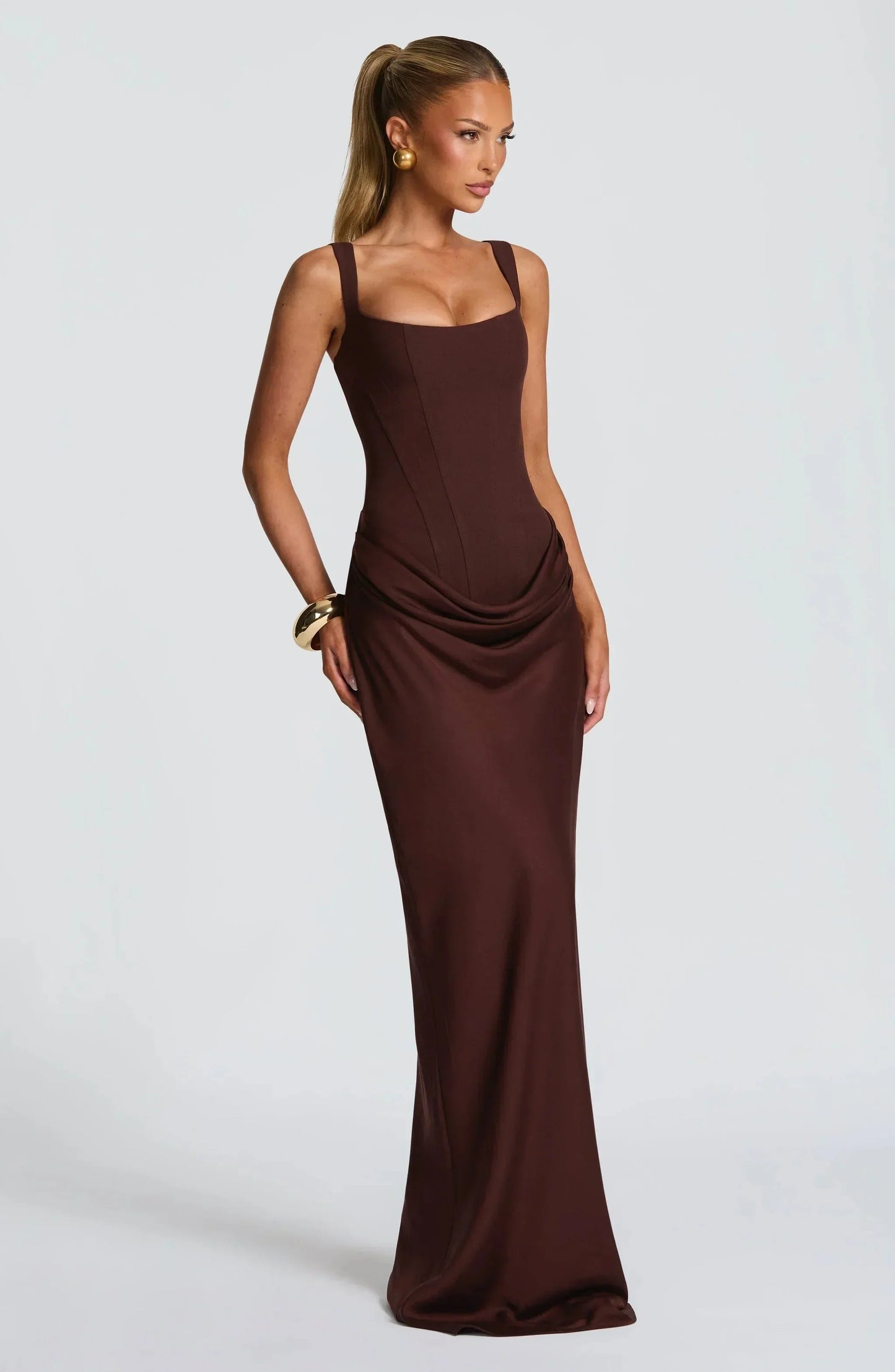 Woman wearing a brown evening gown on a white background