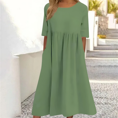 Green dress worn by a person standing outdoors with a blurred background