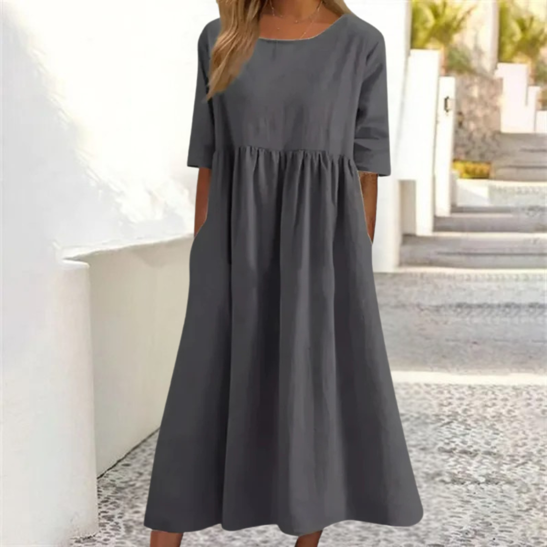 Gray dress worn by a person standing outdoors with a blurred background
