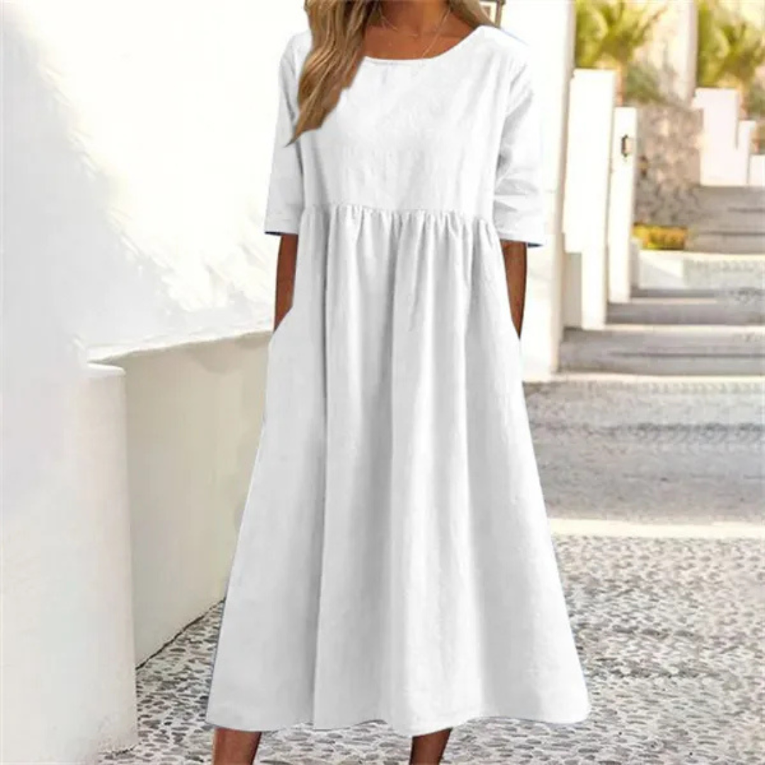 White dress worn by a person standing outdoors with a blurred background