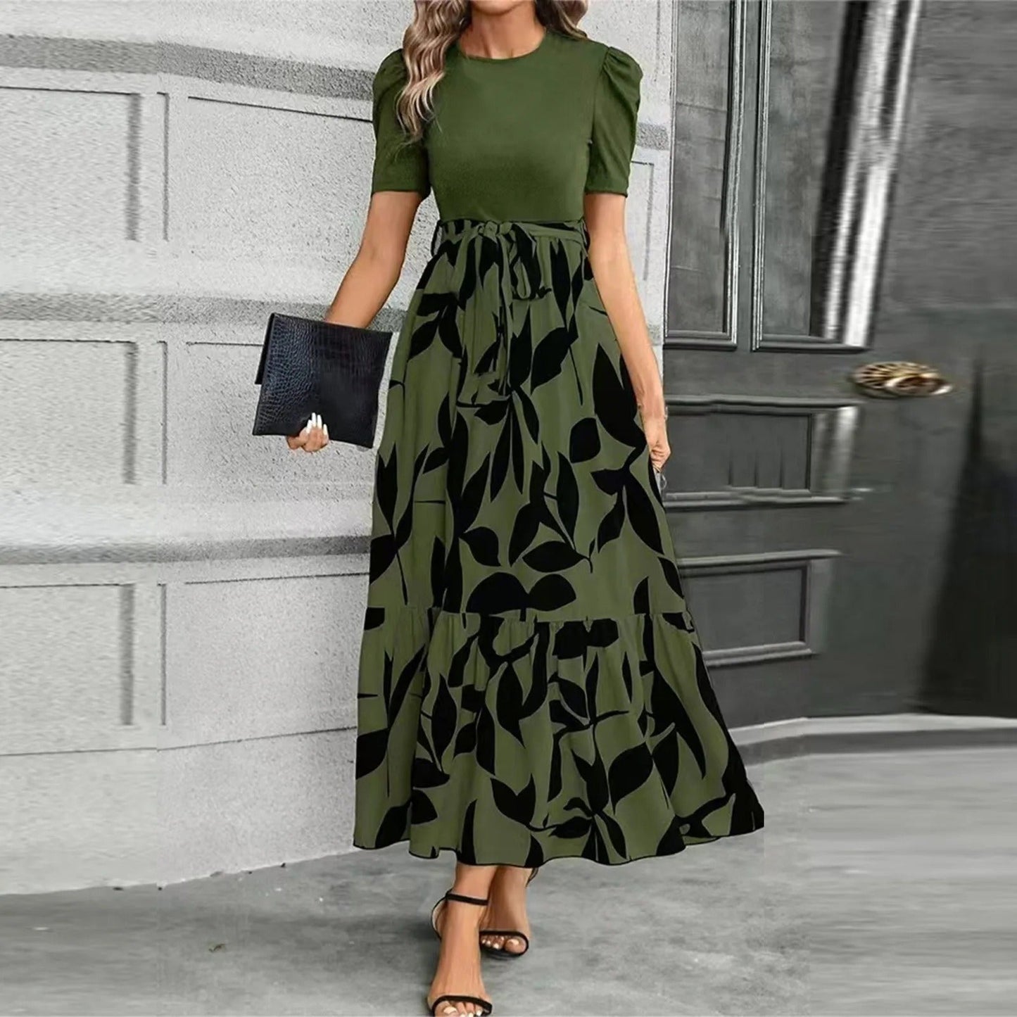 Woman wearing a green dress with black leaf pattern in an indoor setting