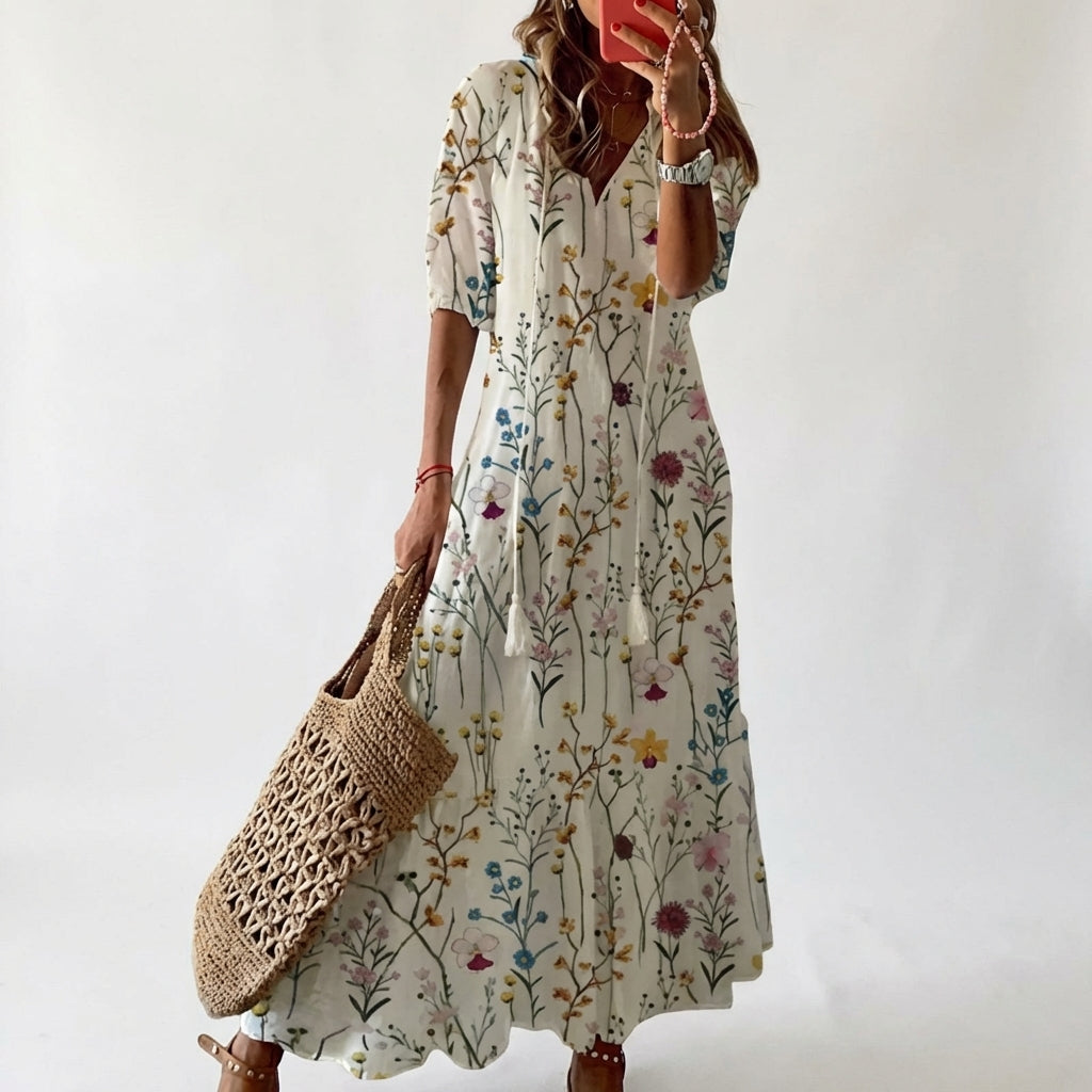 Woman wearing a floral dress holding a woven bag against a white background