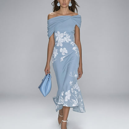 Woman wearing a light blue off-shoulder dress with floral patterns on a gray background